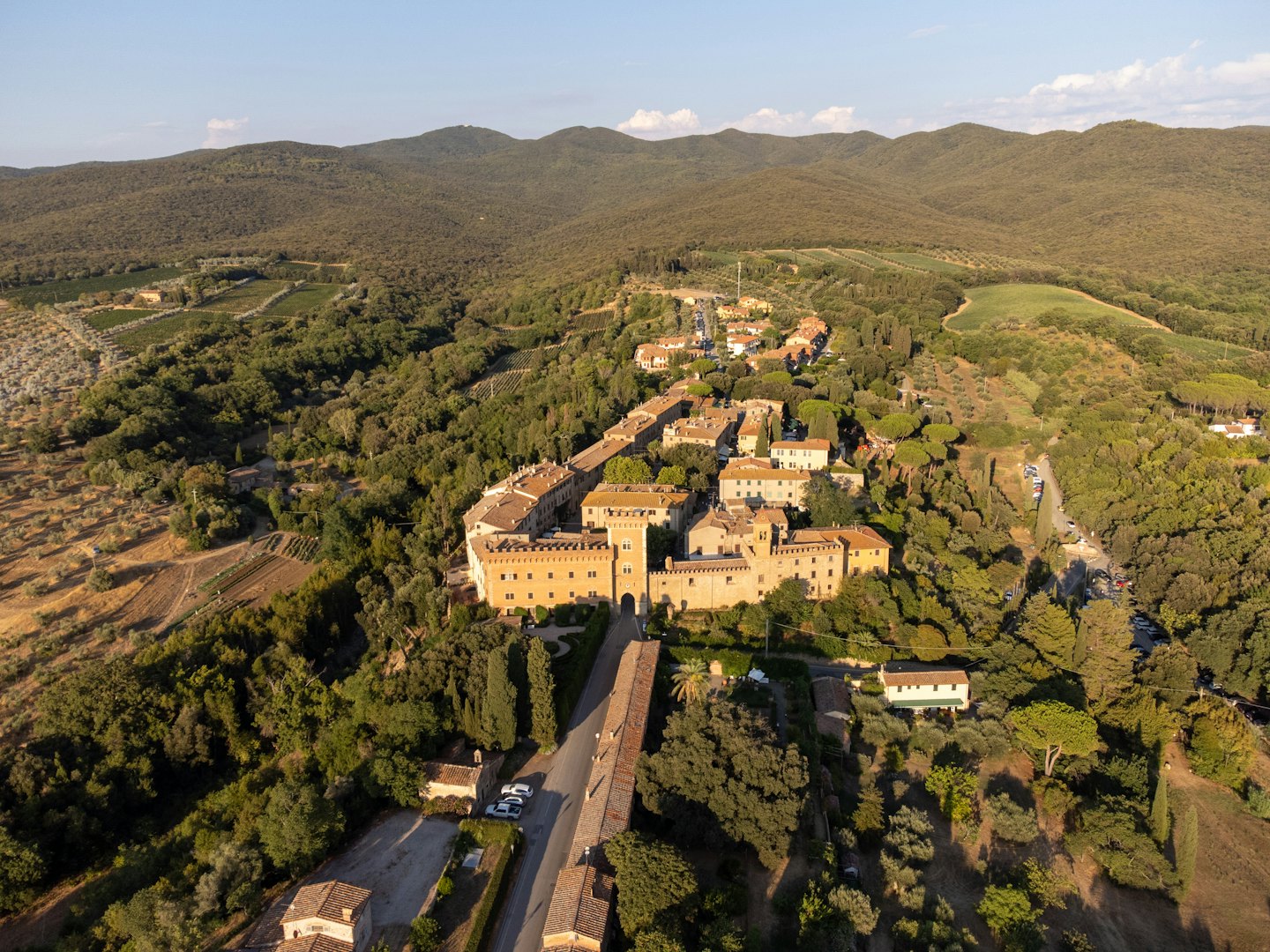 Borgo medievale in pietra immerso in una rigogliosa valle verde.